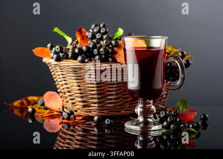 Glas Aroniabeer und frische Beeren im Korb. Stockfoto