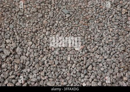 Nahaufnahme der Textur einer Oberfläche, die vollständig mit feinem Schotter bedeckt ist. Stockfoto