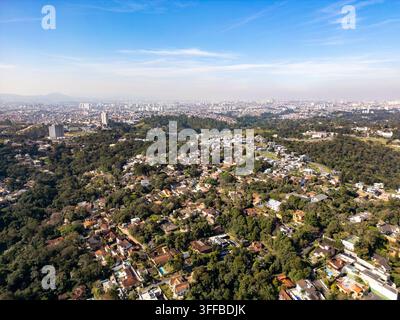 Panoramablick auf São Paulo aus Carapicuíba, Brasilien, mit sowohl den grünen Wohngebieten als auch der riesigen Stadt im Blick. Stockfoto