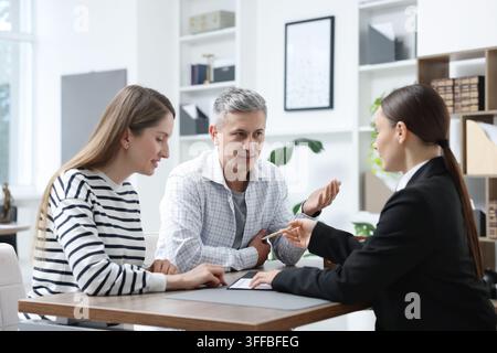 Notar arbeitet mit Klienten am Tisch im Büro Stockfoto