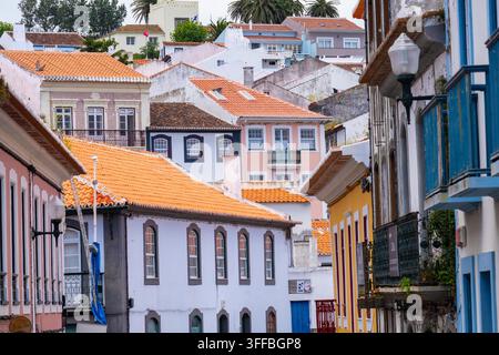 Traditionelle azorische Häuser, weiß getüncht mit farbenfrohem Zierwerk und roten Ziegeldächern in Angra do Heroismo, Portugal, Terceira-Insel, Azoren, Portugal. Stockfoto