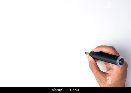 Hand, die einen schwarzen Marker hält, um vor einem leeren weißen Hintergrund zu schreiben. Kopierraum für Text. Stockfoto