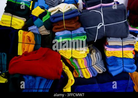 Bunte Stoffrollen und Textilmaterialien, gestapelt in einer Bekleidungsherstellungswerkstatt Stockfoto