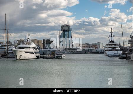 Luxusyachten im Hafen von Port Vell mit der Torre Sant Sebastià in Barcelona Stockfoto