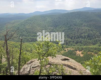 Fels, der einem menschlichen Gesicht ähnelt, mit Blick auf das östliche Rhodopengebirge in der Nähe von Nochevo, Bulgarien Stockfoto