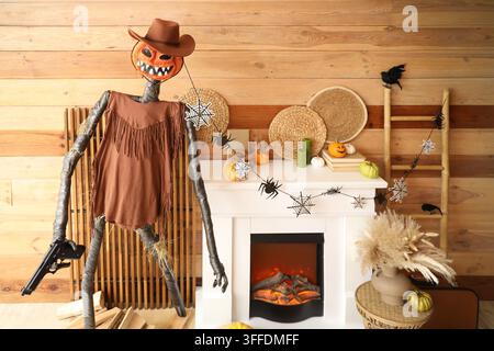Innenraum des festlichen Wohnzimmers mit Leiter, Spooky Halloween Monster, Couchtisch und Herbstdekoration am Kamin Stockfoto