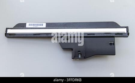Ein schwarzes plastisches elektronisches Bauteil mit einem Barcodelabel liegt auf einem grauen Hintergrund Stockfoto