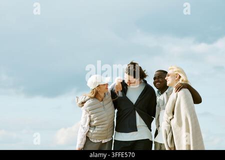 Verschiedene Gruppe von Freunden geht und lacht im Freien Stockfoto