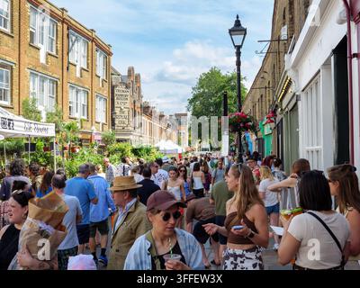 Viele Menschen drängten sich in die Columbia Road an einem geschäftigen Sonntag auf dem Blumenmarkt in London, UK Stockfoto