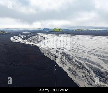 Luftbild des Vulkans Maelifell mit lebendigen grünen moosigen Hängen, umgeben von einem weiten geflochtenen Gletscherfluss und dunklen vulkanischen Sandebenen in Skaftarhr Stockfoto