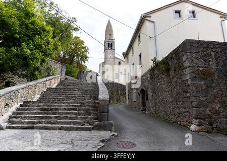 Schöne historische Steintreppe, die durch barocke Portale zum erhöhten Innenhof der St.-Daniel-Kirche im Dorf Stanjel hinaufführt Stockfoto