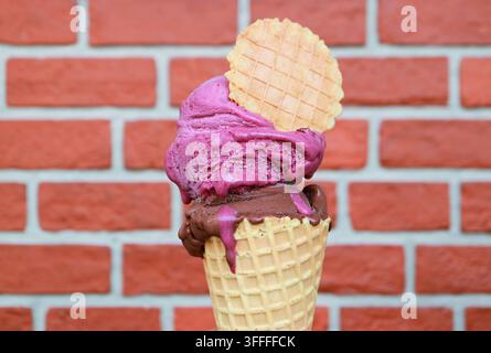 Nahaufnahme einer schmelzenden italienischen Kunsthandwerker-Eiswaffel mit Waffelkeks-Dekor im Sommer Stockfoto