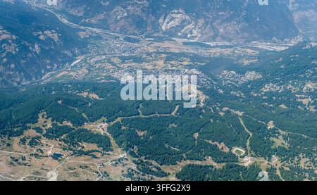 große Luftpanoramalandschaft mit Blick auf das Touristenstädtchen Sestriere von Osten, aufgenommen von einem Segelflugzeug im hellen Sommerlicht, Italien Stockfoto