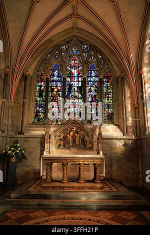 Innenraum der Lady Chapel, Chichester Cathedral, West Sussex, mit dem kunstvoll verzierten Altar, den Buntglasfenstern und der reich verzierten gotischen Gewölbedecke. Stockfoto