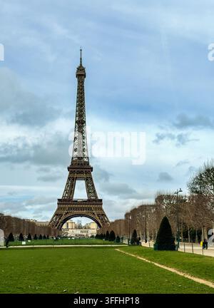 Paris, Frankreich, Europa - 16. Januar 2026: Eiffelturm, gesehen vom östlichen Ende der Champs de Mars vor einer blauen Wolkenlandschaft Stockfoto