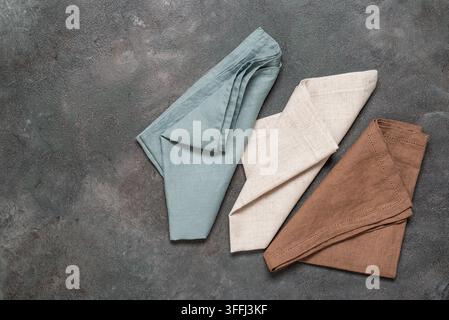 Farbige Leinenservietten auf einem dunklen rustikalen Hintergrund. Oberblick, Flat Lay. Stockfoto