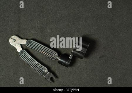3-in-1-Gitarren-Werkzeug mit Saitenschneider, Stimmwirbel-Aufscreuber und Stegboden-Entferner, isoliert auf schwarzem Hintergrund. Stockfoto