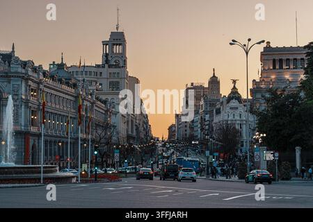 Madrid, Spanien: 7. Apr. 2025 – Der beleuchtete Cibeles-Brunnen sprüht Wasser in den Dämmerungshimmel auf der Plaza de Cibeles in Madrid, eingerahmt von verzierten Landm Stockfoto