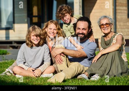 Porträt einer multigenerationellen Familie, die im Freien auf dem Rasen sitzt Stockfoto