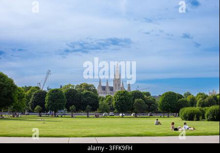 Gartenpark Wiener Rathaus vom Volksgarten aus mit entspannenden Menschen unter blauem Sommerhimmel. Wien, Österreich - 21. Juni 2026 Stockfoto