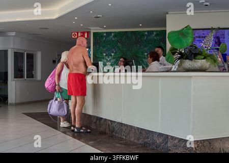 Las Palmas de Gran Canaria, Spanien - 9. September 2026: Gäste, die an einem modernen Hotelrezeptionstresen mit Personal einchecken. Stockfoto