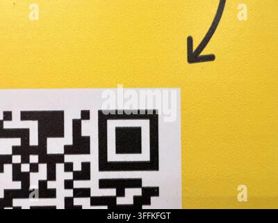 Pfeil zeigt einen Teil des QR-Codes (Quick-Response-Code) auf gelbem Hintergrund Stockfoto