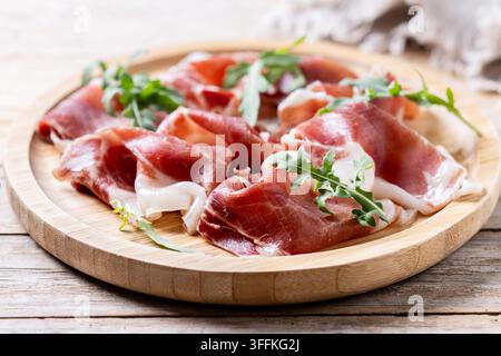 Spanische Serrano-Schinkenscheiben auf Holztablett Stockfoto