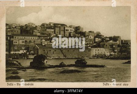 Allgemeiner Blick auf Jaffa vom Meer aus, Palästina, circa 1920. Die Altstadt erhebt sich auf ihrem Tell über der Hafenfront, wobei der lange geschlossene Zoll- und Regierungsbereich aus der osmanischen Zeit die Uferpromenade dominiert und die vor der Küste liegenden Felsen, die traditionell als Andromedas Felsen identifiziert werden, im Vordergrund stehen. Segelboote liegen am Kai vertäut. Diese Skyline existiert nicht mehr: Die Abrisse des britischen Mandats von 1936 rissen breite Straßen durch das Viertel, und weitere Zerstörungen folgten während des Krieges von 1948. Veröffentlicht vom Cairo Postcard Trust, Kairo, Serie 640. Stockfoto