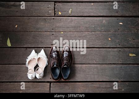 Die Schuhe der Braut und des Bräutigams, insgesamt zwei Paar, wurden nebeneinander auf dem natürlichen Holzweg platziert, während sie vor dem Zeremonienraum warteten. Stockfoto