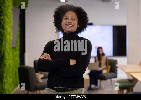 Afroamerikanische Kollegen, die in der Bürolounge arbeiten, mit einem Mann im Rollkragenpullover Stockfoto