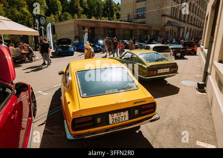 Kemptthal, Zürich, Schweiz, 6. September 2026. Klassische gelbe und grüne Datsun-Z-Sportwagen, die während eines Auto-Enthusiasten-Treffens in einem Außenhof geparkt sind Stockfoto
