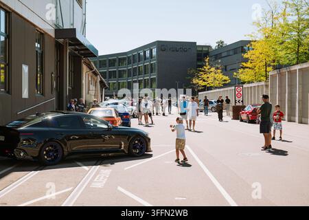 Kemptthal, Zürich, Schweiz, 6. September 2026. Straßenansicht von Menschen und Autos bei einem Fahrzeugtreffen vor dem modernen Firmengebäude von Givaudan Stockfoto