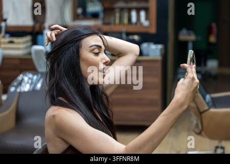 Frau filmt sich selbst für soziale Medien, überprüft Haare und Make-up Stockfoto