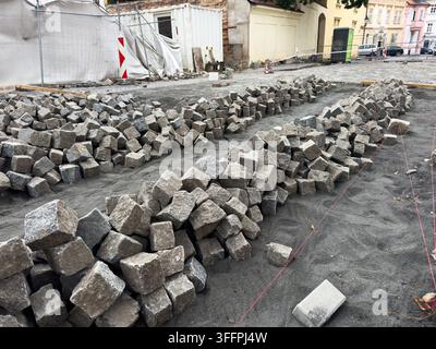 Haufen von Granitpflastersteinen auf einer Straßenbaustelle, städtische Sanierung Stockfoto