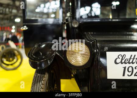 Mailand, Italien - 12.11.2022: Vintage-Scheinwerfer und Rad einer schwarzen Limousine im Nahaufnahme bei einer Ausstellung. Ausstellung Milano Autoclassica Stockfoto
