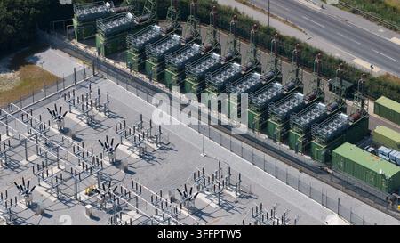 Luftaufnahme eines Batterie-Energie-Speichersystems neben einem elektrischen Umspannwerk mit Industriecontainer-Einheiten, Transformatoren, Stromausrüstung, Zäun Stockfoto
