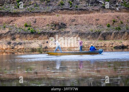 Füttern von Fischen mit einer Schaufel mitten auf einem großen See in einem Motorboot Stockfoto