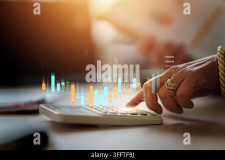 Geschäftsperson verwendet einen Taschenrechner mit digitaler Aktienkurs-Chart-Überlagerung zur Finanzplanung Stockfoto