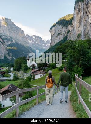 Ein Paar genießt einen ruhigen Spaziergang gemeinsam auf einem malerischen Weg in Lauterbrunnen, Schweiz, umgeben von majestätischen Bergen und bezaubernden Dörfern. Der Stockfoto