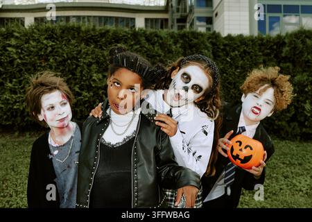 Porträt von vielfältigen Kindern, die Halloween in Kostümen im Freien feiern Stockfoto
