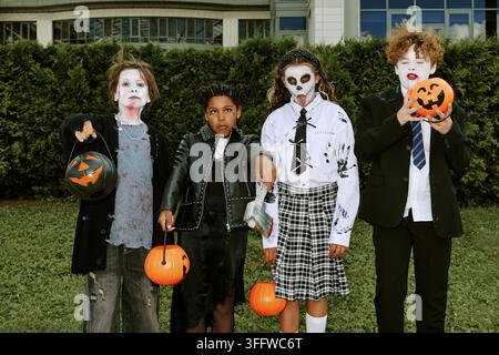 Porträt von vielfältigen Kindern in Halloween-Kostümen im Freien Stockfoto