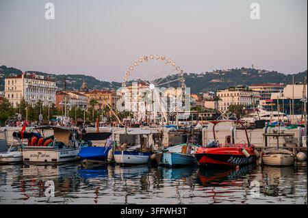 Cannes, Frankreich – 30. Juli 2026: Boote legen im Hafen vor einer Uferpromenade mit einem großen Riesenrad an. Stockfoto