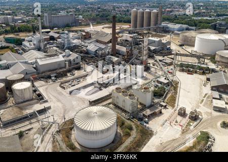 Luftaufnahme eines Zuckerrafineriekomplexes mit großen industriellen Lagersilos und Verarbeitungsgebäuden an einem hellen Sonnentag in einer städtischen Umgebung Stockfoto
