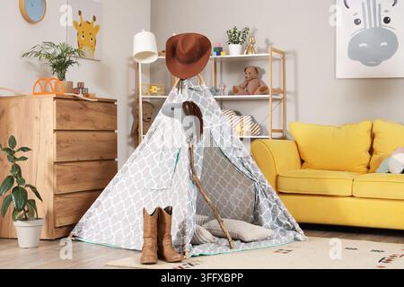 Innenraum eines Kinderzimmers mit Spielzelt, Cowboyhut und Stiefeln Stockfoto