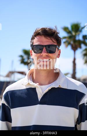 Junger Mann mit Sonnenbrille in der Yachthafenanlage Stockfoto