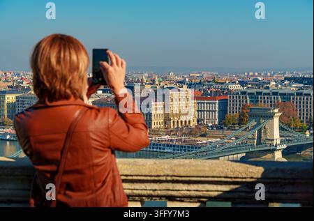 Ein Tourist macht ein Foto von der Budapester Panoramaansicht, einer wunderschönen Stadtsilhouette mit Blick auf die Stadt und die Donau mit der Kettenbrücke und wunderschön Stockfoto