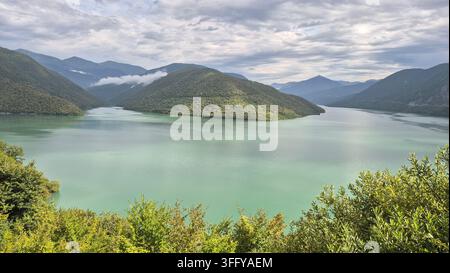 Türnisches Wasser des Zhinvali-Stausees, umgeben von grünen Bergen entlang der Georgischen Militärstraße Stockfoto