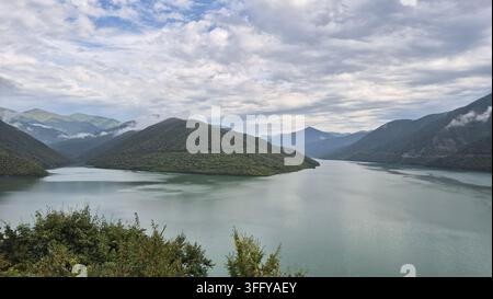 Türnisches Wasser des Zhinvali-Stausees, umgeben von grünen Bergen entlang der Georgischen Militärstraße Stockfoto