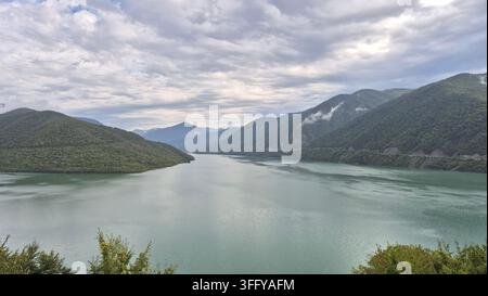 Türnisches Wasser des Zhinvali-Stausees, umgeben von grünen Bergen entlang der Georgischen Militärstraße Stockfoto