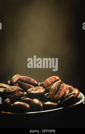 Geröstete Kaffeebohnen auf einem Löffel Makroaufnahme mit dunklem Hintergrund Stockfoto